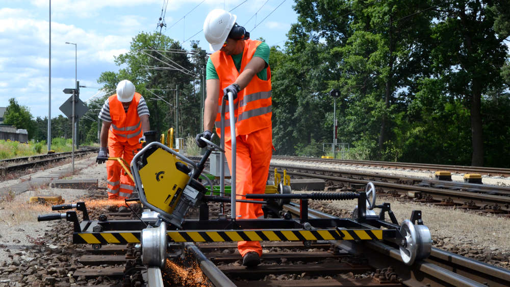 Männer schleifen Bahnschienen Männer schleifen Bahnschienen