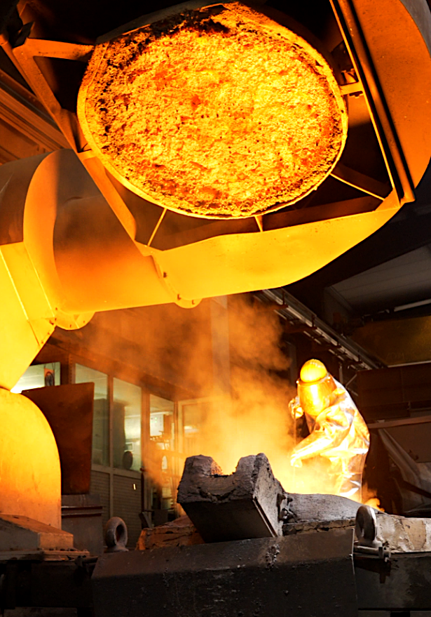 Altmetall wird eingeschmolzen, Mann im Schutzanzug Altmetall wird eingeschmolzen, Mann im Schutzanzug
